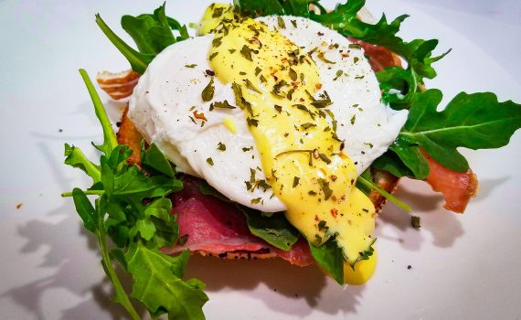 Eggs benedict with prosciutto and arugula_label